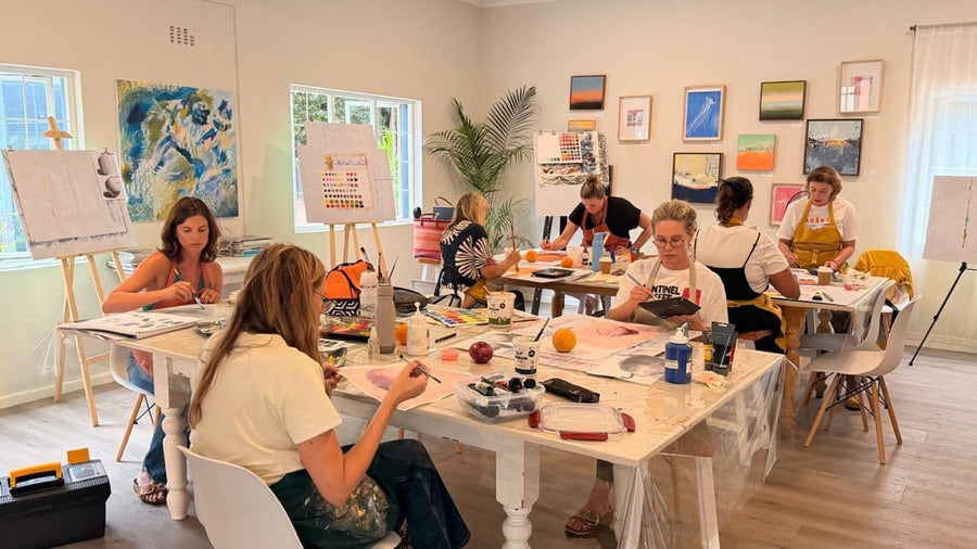 Adults painting at the long white table in the SA Art Fair studio